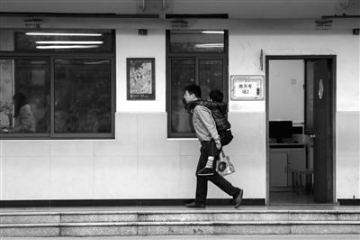 12月10日，春蕾杯德天实验小学考点，一位父亲背着脚部受伤的儿子寻找二年级数学的考场。 