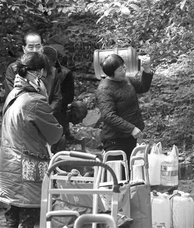 一位大姐兴高采烈扛起接好的泉水回家 一位大姐兴高采烈扛起接好的泉水回家