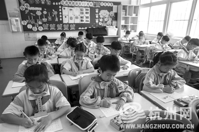 昨天滨江一小二（2）班的小学生在教室里使用写字矫正器上课。 