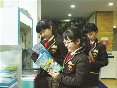 同学们在“绿水青山书架”前看书
