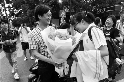 昨天学军中学门口，一位老爸手捧鲜花送给女儿。