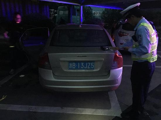 交警在盘问滴滴车司机。